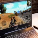 Ilustrasi download game favorit dengan berbagai platform di laptop.