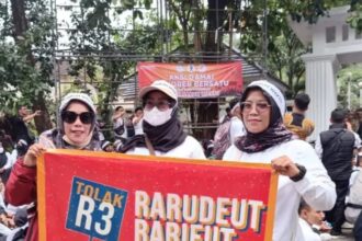 Massa aksi membawa spanduk berisi penolakqn skema PPPK paruh waktu dan meminta pengangkatan sebagai pegawai penuh waktu. (Prima Arno/Telusur Bisnis)