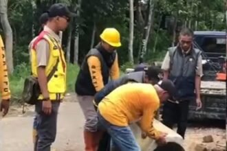 Petugas dari UPTD PU Wilayah Jampangkulon memperbaiki sementara sebuah gorong-gorong yang amblas