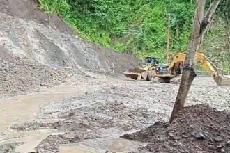 Alat berat Beko membersihkan jalan nasional di Desa Loji dari material longsor susulan. (Prima Arno/Telusur Bisnis)