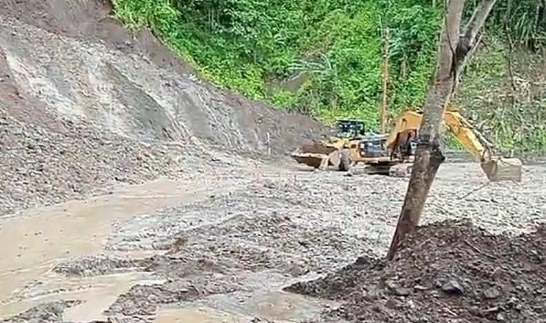 Alat berat Beko membersihkan jalan nasional di Desa Loji dari material longsor susulan. (Prima Arno/Telusur Bisnis)