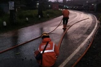 Petugas membersihkan sisa material longsor yang sempat menimbun ruas jalan Provinsi di Kecamatan Nyalindung, Kabupaten Sukabumi. (Prima Arno/Terlusurbisnis)