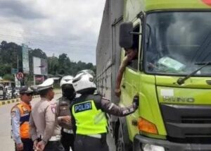 Petugas menghentikan truk sumbu tiga yang nekat tetap beroperasi di exit tol Parungkuda. (Prima Arno/Telusurbisnis)