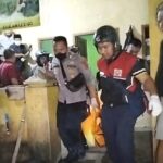 Petugas mengevakuasi mayat pria tanpa identitas yang tewas di bak mandi rumah kosong. (Prima Arno/Telusurbisnis)