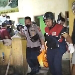 Petugas mengevakuasi mayat pria tanpa identitas yang tewas di bak mandi rumah kosong. (Prima Arno/Telusurbisnis)