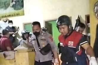 Petugas mengevakuasi mayat pria tanpa identitas yang tewas di bak mandi rumah kosong. (Prima Arno/Telusurbisnis)