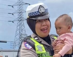 Aipda Devi, Polwan Satlantas Polres Sukabumi Mengamankan bayi kepanasan saat arus balik lebaran di sekitar GT Parungkuda, Sukabumi. (Prima Meidiandi/Telusurbisnis)