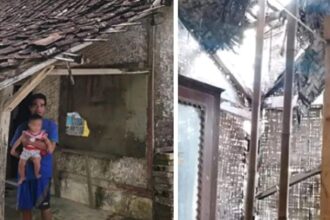 Ketua RT Dadan bersama bayinya di depan rumahnya yang nyaris ambruk. (Prima Meidiandi/Telusurbisnis)