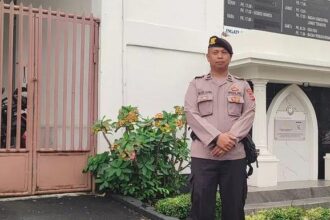 Petugas melakukan pengamanan gereja dalam program Minggu Kasih Polsek Baros. (Prima Meidiandi/Telusurbisnis)