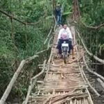 Jembatan Gantung Jantake yang akan diperbaiki. Tampak seorang warga nekat menyeberangi jembatan dengan motor. (Prima Meidiandi/Telusurbisnis)